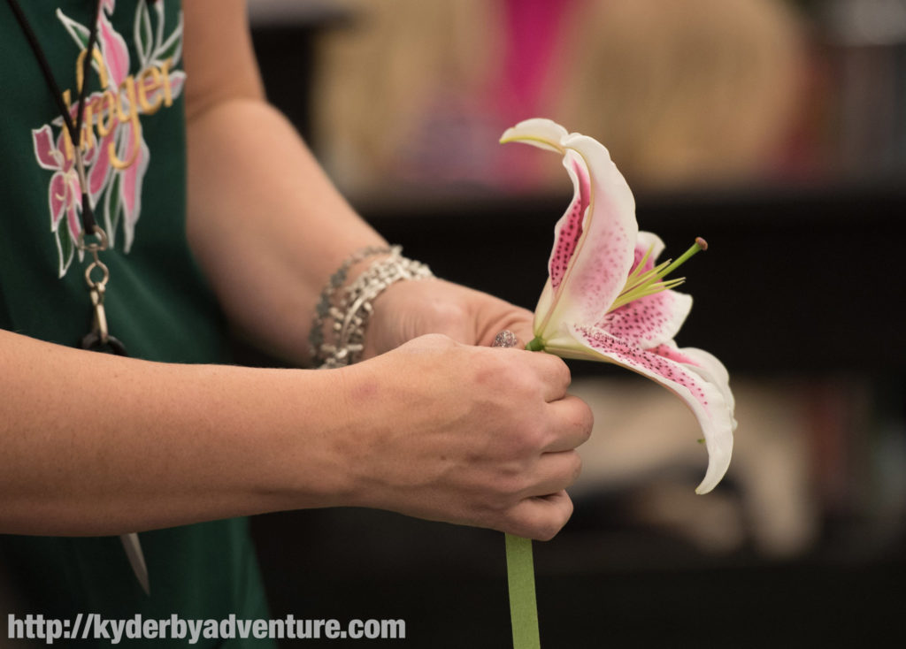 A Kroger florist tapes up a lily blossom before she adds it to the Garland of Lilies.