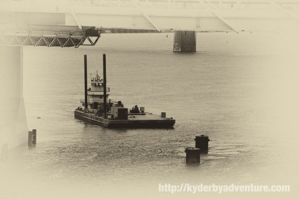 A boat works the Ohio River near the Kennedy Bridge.