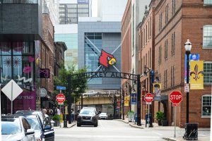 A view down Louisville's Washington Street, also know as Whiskey Alley. The Yum Brands Arena with the University of Louisville Cardinal Logo can be seen at the end.